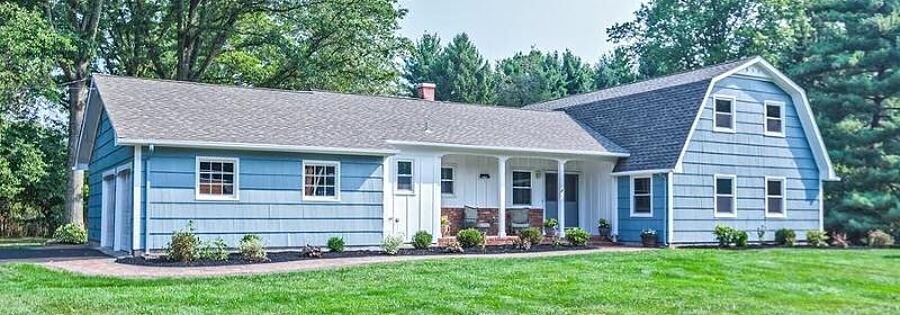 Blue ranch house with white trim after an exterior repaint