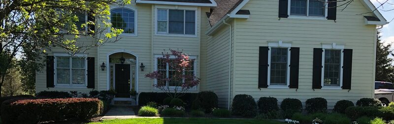 Yellow colonial home with fresh white trim and black shutters