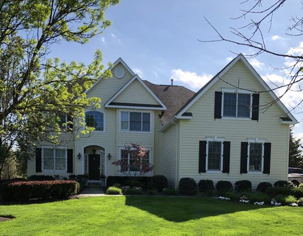 Front elevation of a yellow colonial with black shutters