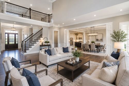 Open living and dining room with light grey walls, white trim and dark hardwood floors